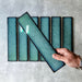 Alchemy Hunter Green 6.5×30cm ceramic wall tiles with a glossy green finish, shown as a group of rectangular tiles.
