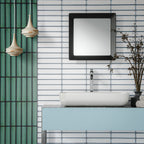Alchemy Magma White 6.5cm x 30cm wall tiles installed horizontally around a modern bathroom vanity, paired with contrasting Alchemy Hunter Green tiles, a white countertop basin and contemporary black-framed mirror.