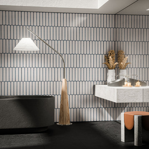 Bathroom featuring Alchemy Magma White 6.5cm x 30cm wall tiles laid vertically, showcasing a soft white finish with contrasting dark edging, paired with a black freestanding bath and contemporary stone-effect vanity.