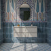Allegra Blue 6cm x 25cm gloss brick wall tiles, featuring rich blue tonal variation throughout a statement bathroom, paired with intricate blue patterned floor tiles and a decorative floral mural.