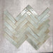 Allegra Celadon Green Gloss Brick ceramic tiles in a 6 × 25cm format, arranged in a herringbone pattern to showcase the soft green tones, glossy finish and subtle handmade-style variation.