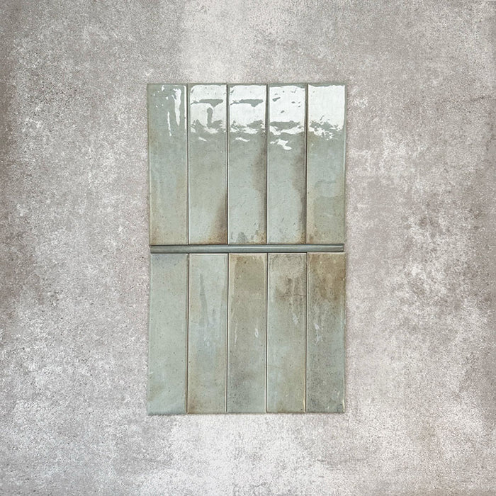 Allegra Celadon Green Gloss pencil bullnose border ceramic tiles in a 1.2 × 30cm format, shown laid vertically to highlight the soft green tones, glossy finish and subtle handmade-style variation, ideal for edging and decorative borders.