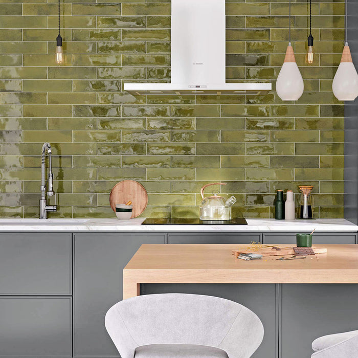 Kitchen splashback featuring Allegra Daisy Green Gloss Brick ceramic tiles in a 6 × 25cm format, creating a vibrant, contemporary look with rich green tones, a glossy finish and subtle handmade-style variation.