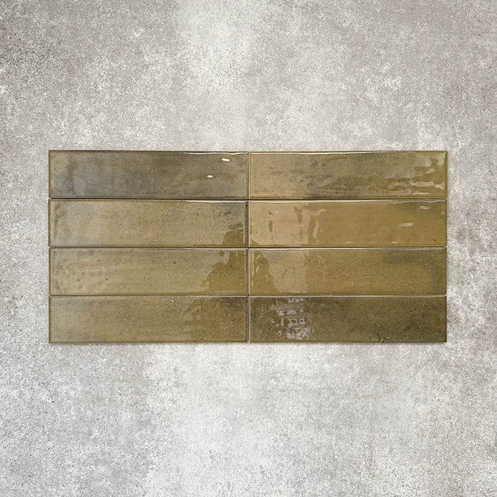 Allegra Daisy Green Gloss Brick ceramic tiles in a 6 × 25cm format, laid horizontally to highlight the rich green tones, glossy finish and subtle handmade-style surface variation.