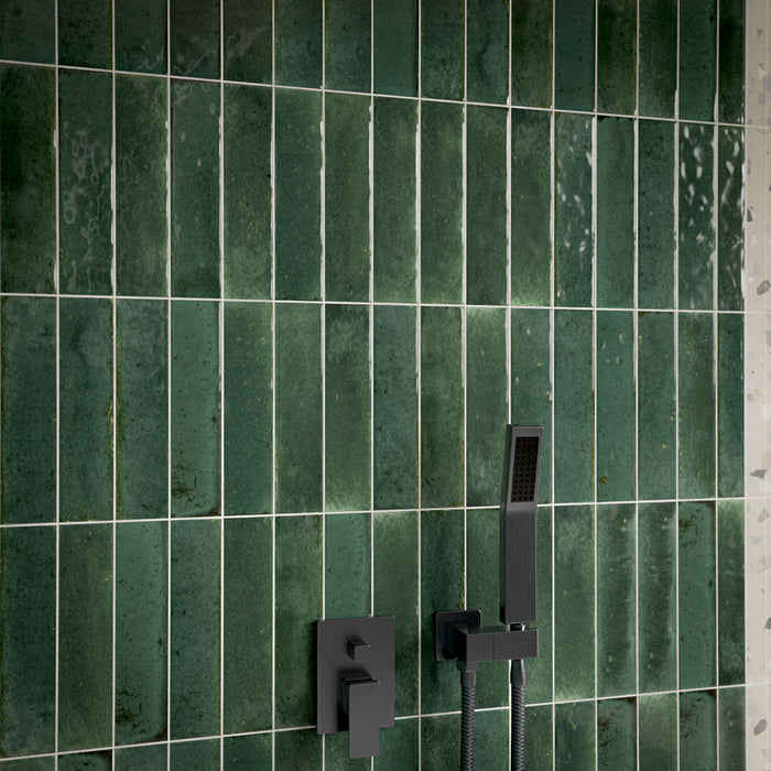 Close-up of Allegra Green 6cm x 25cm gloss brick tiles in a shower, showcasing rich green tonal variation and a glossy finish, paired with contemporary matt black shower fixtures.