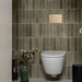 Bathroom wall featuring Allegra Sage Green Gloss Brick ceramic tiles in a 6 × 25cm format, laid vertically to create a refined, contemporary look with muted green tones, a glossy finish and subtle handmade-style variation.