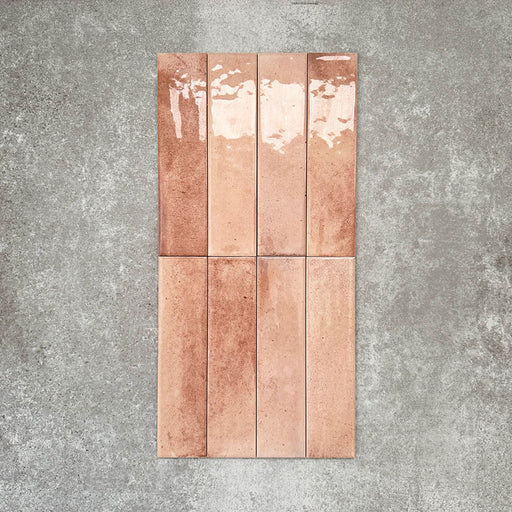 Allegra Tusk Pink Gloss Brick ceramic tiles in a 6 × 25cm format, shown laid vertically to highlight the soft pink tones, glossy finish and subtle handmade-style variation.