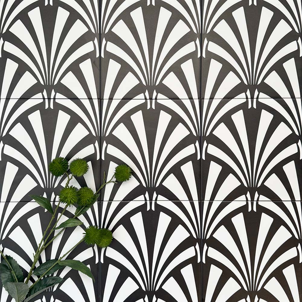 Almeria Casablanca Moroccan-style porcelain wall and floor tiles arranged in a repeating black and white fan pattern, 20x20cm, styled with greenery for a decorative display.