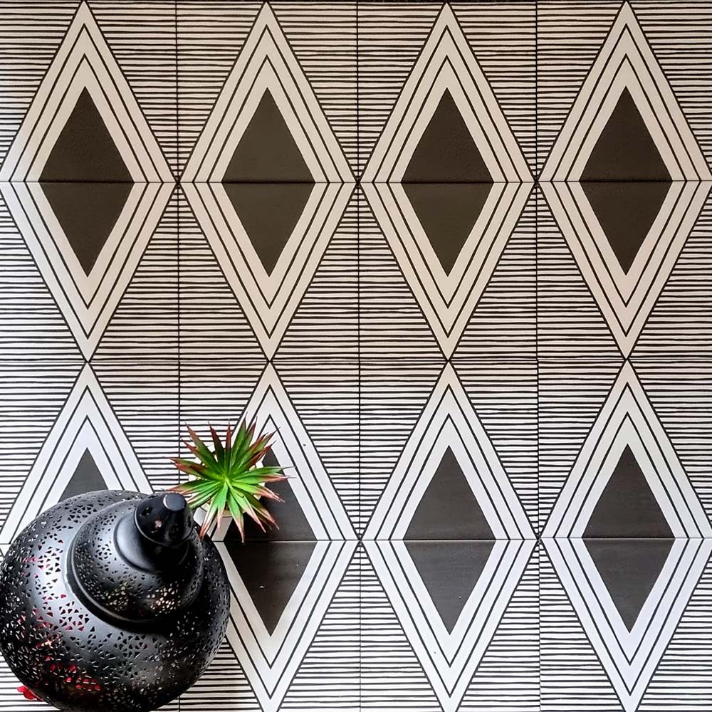 Almeria Giza Moroccan-style porcelain wall and floor tiles laid in a repeating black and white geometric triangle pattern, 20x20cm, creating a bold and decorative tiled surface.