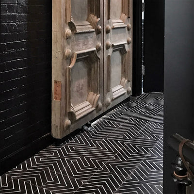 Hallway floor featuring Almeria Jilani Black Moroccan-style porcelain tiles in a striking white line geometric chevron pattern, 20x20cm, creating a bold and contemporary walkway.