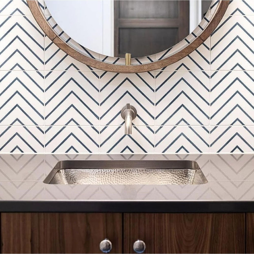 Bathroom sink area featuring Almeria Jilani White Moroccan-style wall tiles in a clean black line chevron pattern, 20x20cm, paired with a round mirror and contemporary basin.
