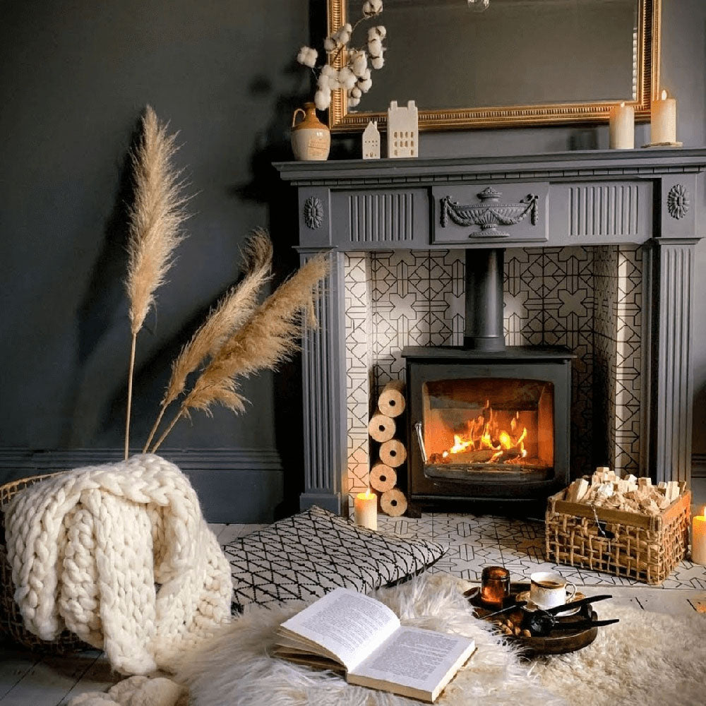 Living room fireplace featuring Almeria Palace Moroccan-style porcelain wall and floor tiles in a soft neutral geometric pattern, 20x20cm, creating a warm and elegant focal point.