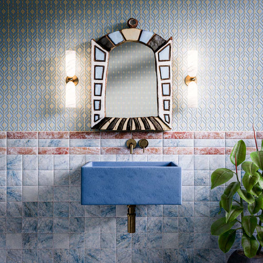 Bathroom featuring Amalfi Square Azul Vintage Marble 11x11cm wall tiles with rich blue marble-effect variation, paired with a matching blue basin, decorative border detail, brass fittings and patterned wallpaper. The combination creates a bold, characterful space with a vintage-inspired Mediterranean feel.