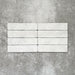 Product image of Amalfi Brick Carrara Vintage Marble wall and floor tiles in a 5.4cm x 22cm format, showcasing a soft white marble effect surface with subtle tonal variation.