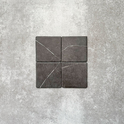Product image of Amalfi Square Nero Vintage Marble wall and floor tiles in an 11cm x 11cm format, showcasing dark charcoal marble-effect porcelain with subtle white veining and softly rounded edges.