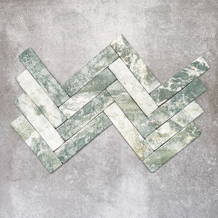 Product image of Amalfi Brick Salvia Vintage Marble wall and floor tiles in a 5.4cm x 22cm format, arranged in a herringbone pattern, showcasing green and white marble effect detailing with natural veining and tonal variation.