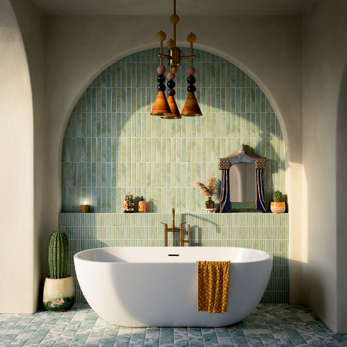 Bathroom featuring Amalfi Salvia Square 11cm x 11cm vintage marble floor tiles, with soft green and white variation, paired with green vertical wall tiles, a freestanding bath and arched detailing.