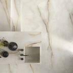Flat lay bathroom vanity featuring Anastasia Pearl Onyx Matt 60 × 120cm stone effect tiles, with soft cream tones and delicate gold veining, paired with black fittings, integrated basin, and minimal, modern styling.