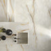 Flat lay bathroom vanity featuring Anastasia Pearl Onyx Matt 60 × 120cm stone effect tiles, with soft cream tones and delicate gold veining, paired with black fittings, integrated basin, and minimal, modern styling.