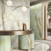 Interior reception space featuring Anastasia Pearl Onyx Polished 60 × 120cm stone effect wall and floor tiles, with soft cream tones and gold veining, paired with a curved statement desk, warm metallic accents, and soft lighting.