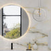 Bathroom vanity detail featuring Anastasia Pearl Onyx Polished 60 × 120cm stone effect wall tiles, with soft cream tones and flowing gold veining, paired with a round illuminated mirror, glass pendant light, and black fittings.