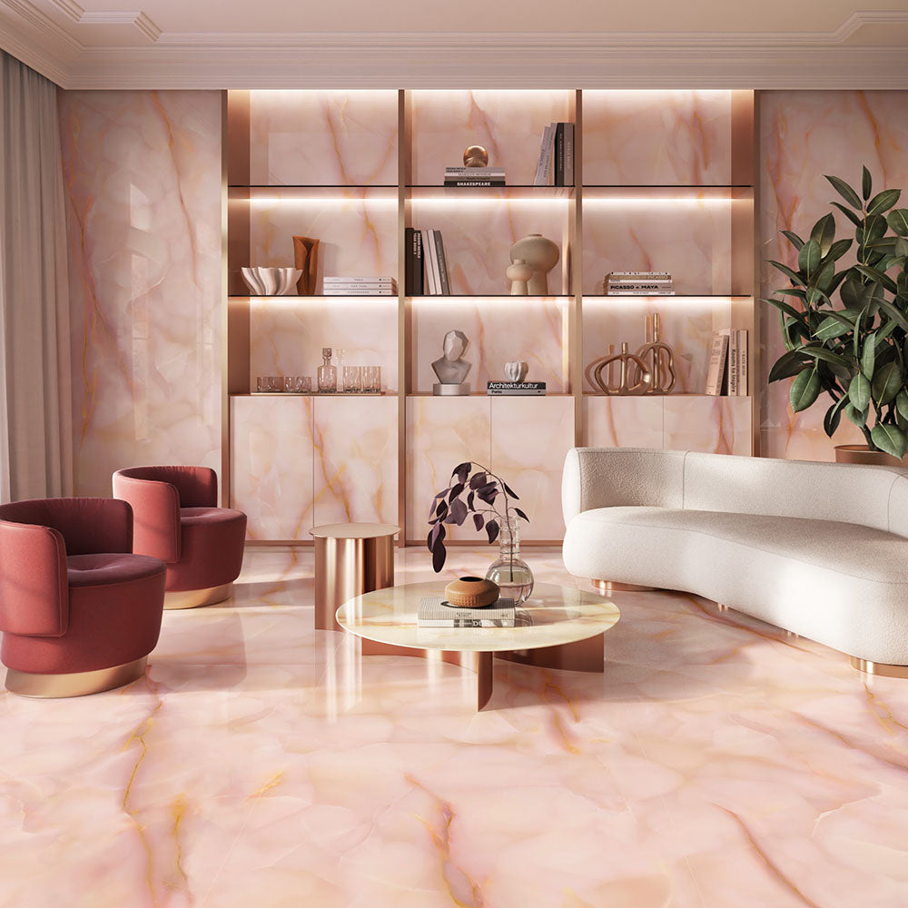Living room featuring Anastasia Rose Onyx Matt 60 × 120cm stone effect floor and wall tiles, with soft pink tones and delicate gold veining, paired with curved seating, warm lighting, and built-in shelving.
