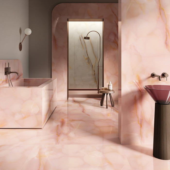 Bathroom interior featuring Anastasia Rose Onyx Matt 60 × 120cm stone effect wall and floor tiles, with soft pink tones and delicate gold veining, paired with a freestanding bath, walk-in shower, and warm brass fittings.