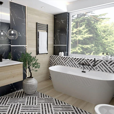 Bathroom interior featuring Art Deco Black & White marble effect patterned porcelain tiles 44 × 44cm, used across the floor and bath panel to create a bold, continuous geometric layout. The contrasting black and white tones introduce strong structure and rhythm, balanced with wood-effect wall panels, a freestanding bath, and matte black fittings for a clean, modern finish.