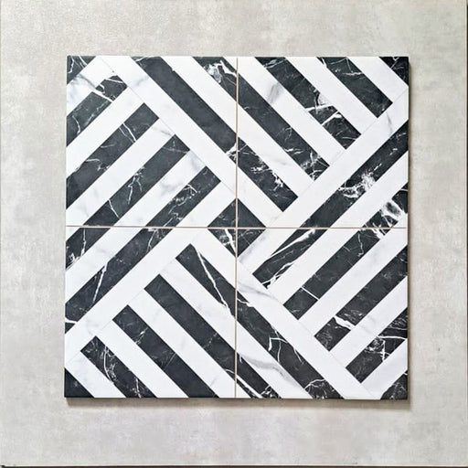 Flat lay of Art Deco Black & White marble effect patterned porcelain tiles 44 × 44cm, arranged to highlight the repeating geometric layout. The contrast between deep black marble effect segments and crisp white lines creates a bold, interlocking pattern with strong visual structure and movement.