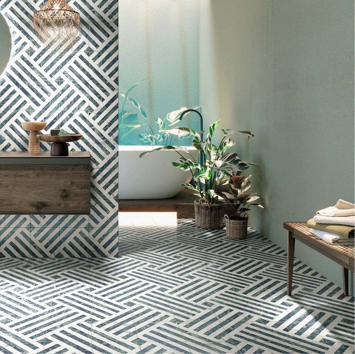 Bathroom interior featuring Art Deco Emerald Green marble effect patterned porcelain tiles 44 × 44cm, used across both wall and floor to create a continuous geometric layout. The bold linear pattern in deep green and white tones adds structure and movement, paired with a freestanding bath, wooden vanity unit, and natural greenery for a balanced, contemporary feel.