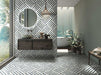 Bathroom interior featuring Art Deco Emerald Green marble effect patterned porcelain tiles 44 × 44cm, used across both wall and floor to create a continuous geometric layout. The bold linear pattern in deep green and white tones adds structure and movement, paired with a freestanding bath, wooden vanity unit, and natural greenery for a balanced, contemporary feel.