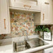 Kitchen splashback featuring Athens Multicoloured Hexagon Patchwork 17x15cm Moroccan-style tiles, displaying a geometric cube-effect pattern in soft pastel and earthy tones, paired with light cabinetry and warm wood handles for a playful yet contemporary finish.