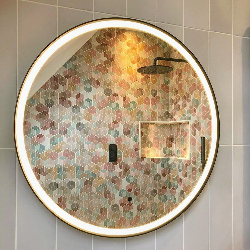 Bathroom feature wall showcasing Athens Multicoloured Hexagon Patchwork 17x15cm Moroccan-style tiles, arranged in a geometric cube-effect pattern in soft pastel and earthy tones, creating a bold yet elegant focal point within a curved shower enclosure.