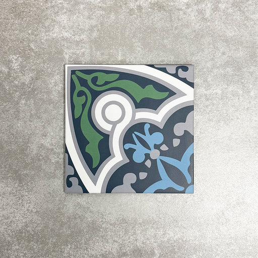 Single London Streets Baker Street 20x20cm Victorian Moroccan style porcelain tile displayed in a product setting, featuring an ornate geometric pattern in blue, green, grey and white tones inspired by traditional decorative Victorian floor tiles.