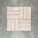 Flat lay of Zellige Pink Mist Brick 6.5 × 20cm Moroccan-style ceramic tiles in soft pale pink and blush tones, arranged in a basketweave layout on a textured grey background, showcasing the glossy glaze, gentle tonal variation and handcrafted zellige-effect finish.