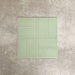 Pimlico Lime Green 7.5 × 15cm ceramic tiles with a crackle glaze finish, shown in a basketweave layout highlighting soft green tones, subtle texture and versatile design options for bathroom or kitchen walls.