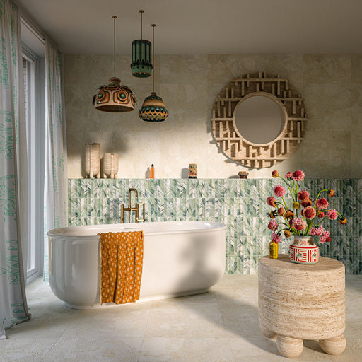 Baresi Puro Light 3D 60cm x 60cm terrazzo effect tiles, covering the bathroom walls and floor in warm neutral tones, paired with green patterned tiles, a freestanding bath and brass fittings.
