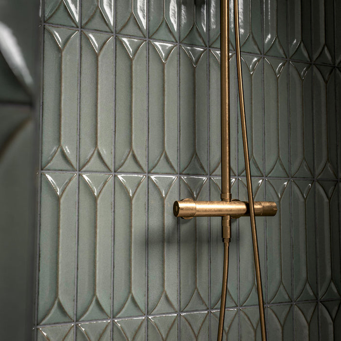 Bathroom vanity area featuring Baroque Decor Lichen Green 9.1x37.5cm porcelain wall tiles, showcasing a glossy fluted design in soft green tones, paired with a stone basin, brass fittings and warm ambient lighting.