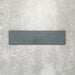 Baroque Laguna Blue porcelain wall and floor tile in a 9.1cm x 37.5cm format, featuring a deep blue metallic finish with gently distressed edges, displayed against a textured concrete-effect background.