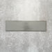 Baroque Lichen Green porcelain wall and floor tile in a 9.1cm x 37.5cm format, featuring a soft sage green metallic finish with gently distressed edges, displayed against a textured concrete-effect background.