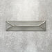 Baroque Decor Lichen Green porcelain wall tile in a 9.1cm x 37.5cm format, featuring a soft sage green metallic finish with a raised geometric relief design and gently distressed edges, displayed against a textured concrete-effect background.