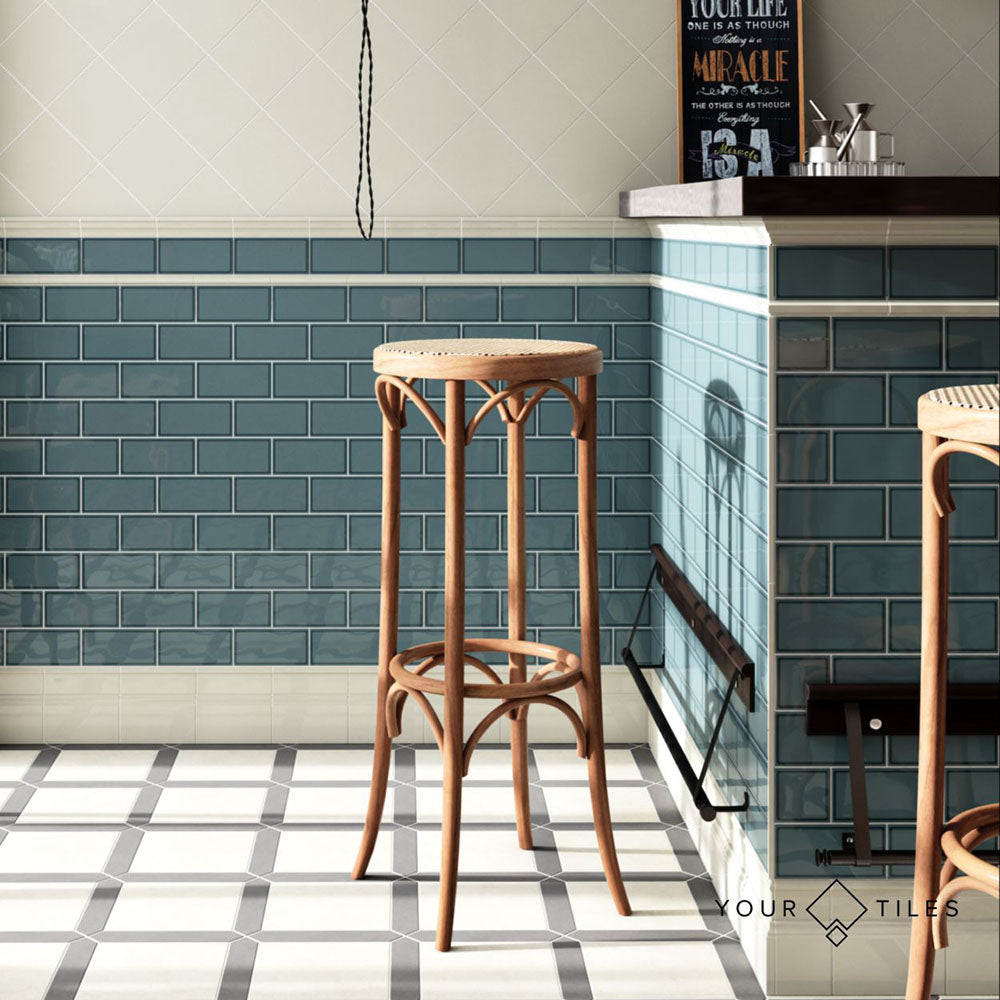 Bar interior featuring Pimlico River Blue 7.5 × 15cm ceramic wall tiles with a crackle glaze finish, laid in a classic brick pattern and paired with bar stools and patterned floor tiles.