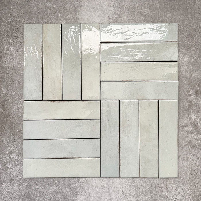 Nomad Mint Green brick wall tiles in a 6 × 24.6cm format, shown laid together in a basketweave layout to highlight the soft green colour, gloss finish and subtle surface variation.