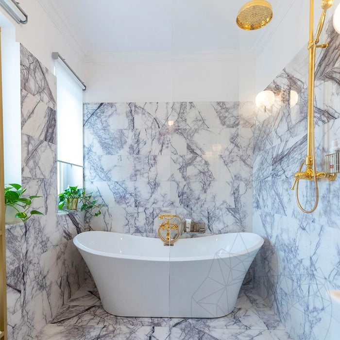 Bathroom interior featuring Fayrouz Lilac 30.5x61cm natural marble tiles with a honed finish, installed across the walls and floor to showcase a white base with soft lilac and grey veining, creating an elegant, spa-like setting with refined natural variation.