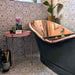 Bathroom featuring Medina Dusty Pink Moroccan-style hexagon porcelain tiles, 18.7 × 21.6 cm, used on walls and floors to create a soft geometric backdrop, styled with a copper bathtub and vintage accessories.