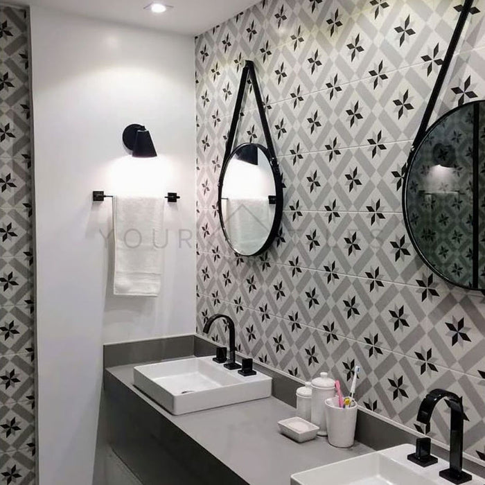 Bathroom featuring Canterbury Star Victorian-style porcelain wall tiles in a 20 × 20cm format, laid in a repeating geometric star pattern and paired with sleek grey vanity units, black fittings and round mirrors for a refined, contemporary bathroom look.