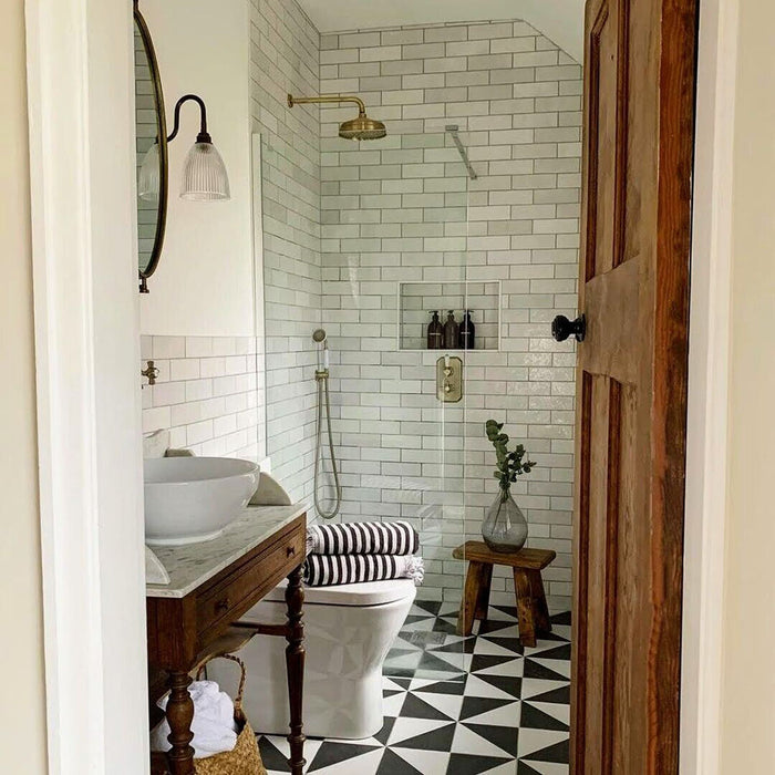 Bathroom featuring Zellige White brick tiles laid horizontally on the walls, paired with patterned floor tiles and brass fittings.