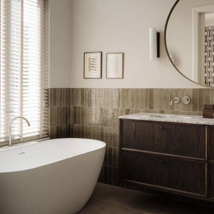 Bathroom walls featuring Allegra Sage Green Gloss Brick ceramic tiles in a 6 × 25cm format, laid vertically to create a calm, contemporary look with muted green tones, a glossy finish and subtle handmade-style variation.