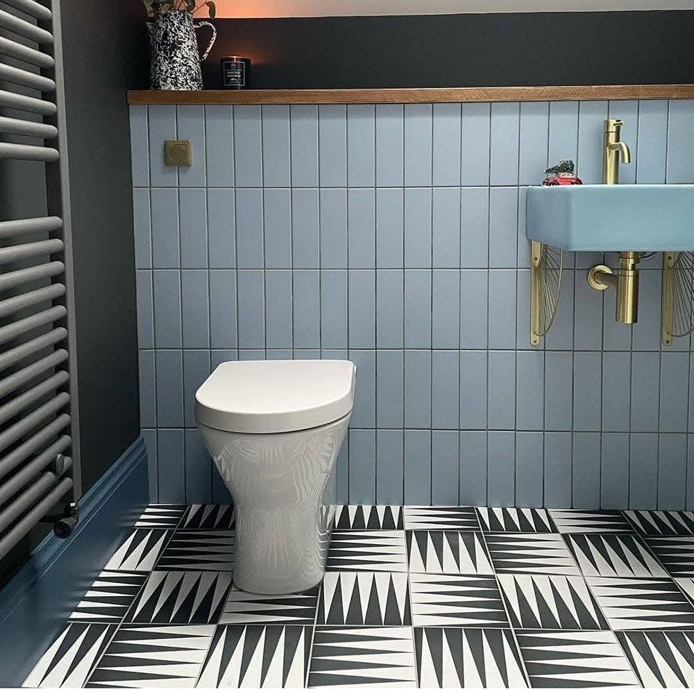 Bathroom featuring Almeria Backgammon Moroccan-style porcelain wall and floor tiles in a bold black and white geometric pattern, 20x20cm, styled with a modern basin and dark painted walls.
