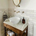 Bathroom featuring Zellige White brick tiles laid horizontally on the walls, paired with patterned floor tiles and brass fittings.
